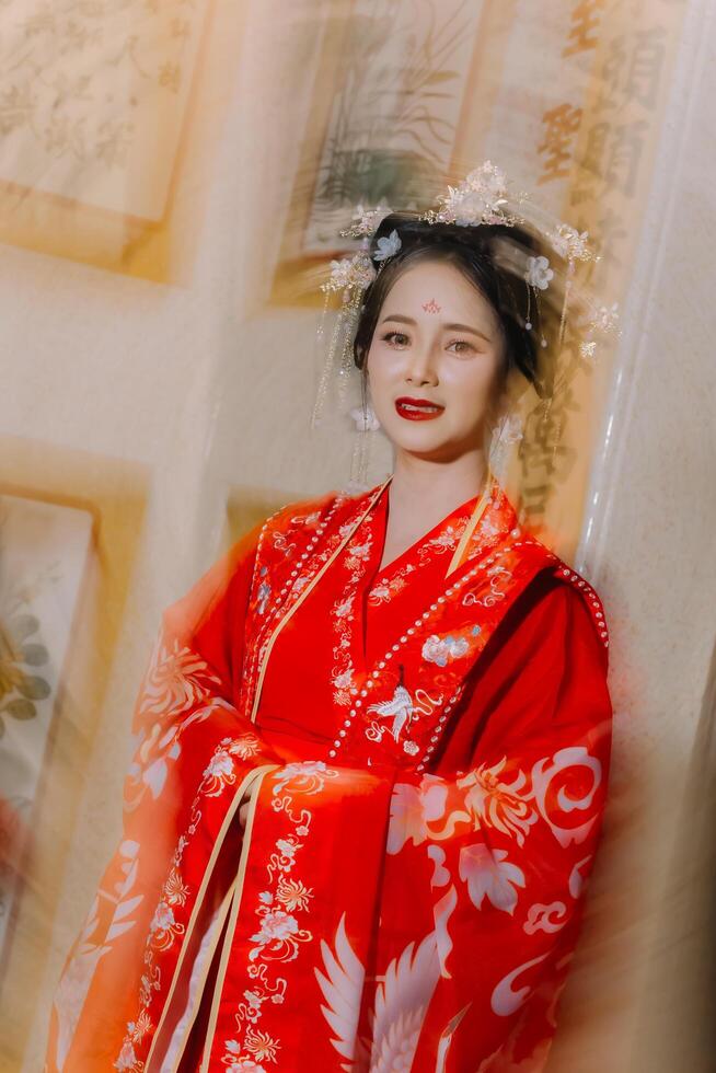 kvinna klänning Kina ny år. porträtt av en kvinna. person i traditionell kostym. kvinna i traditionell kostym. skön ung kvinna i en ljus röd klänning och en krona av kinesisk drottning Framställ. foto