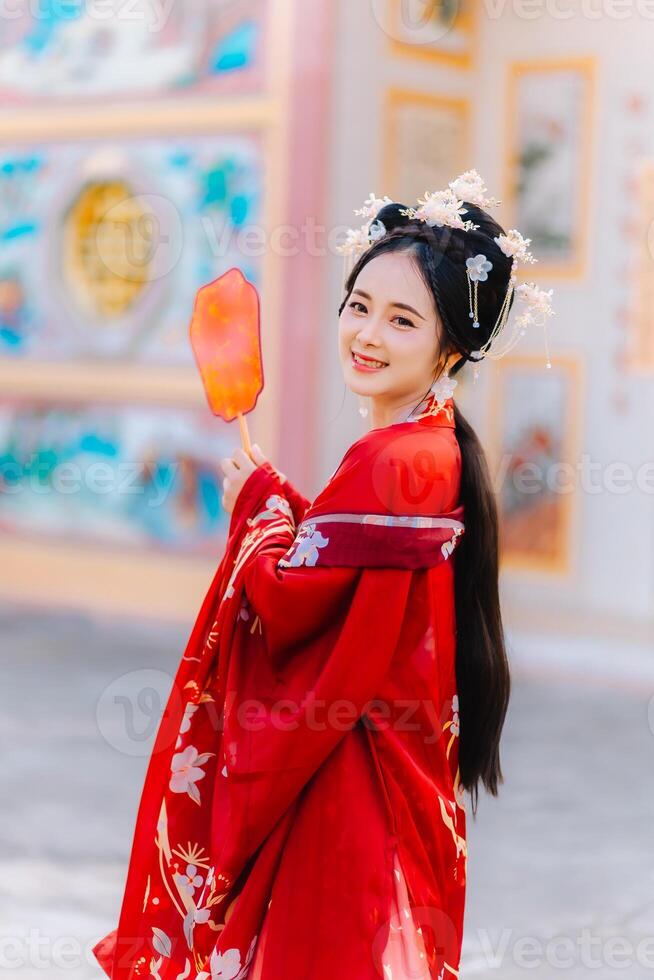 kvinna klänning Kina ny år. porträtt av en kvinna. person i traditionell kostym. kvinna i traditionell kostym. skön ung kvinna i en ljus röd klänning och en krona av kinesisk drottning Framställ. foto