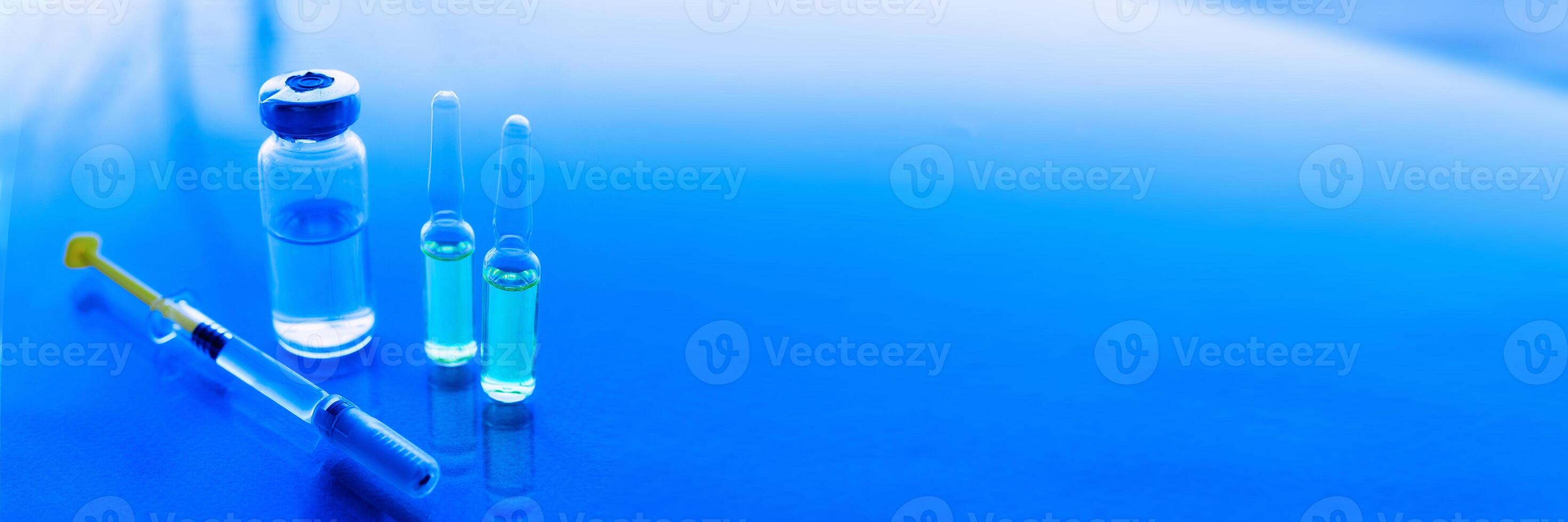 sprutor, medicin flaskor på en blå bakgrund foto