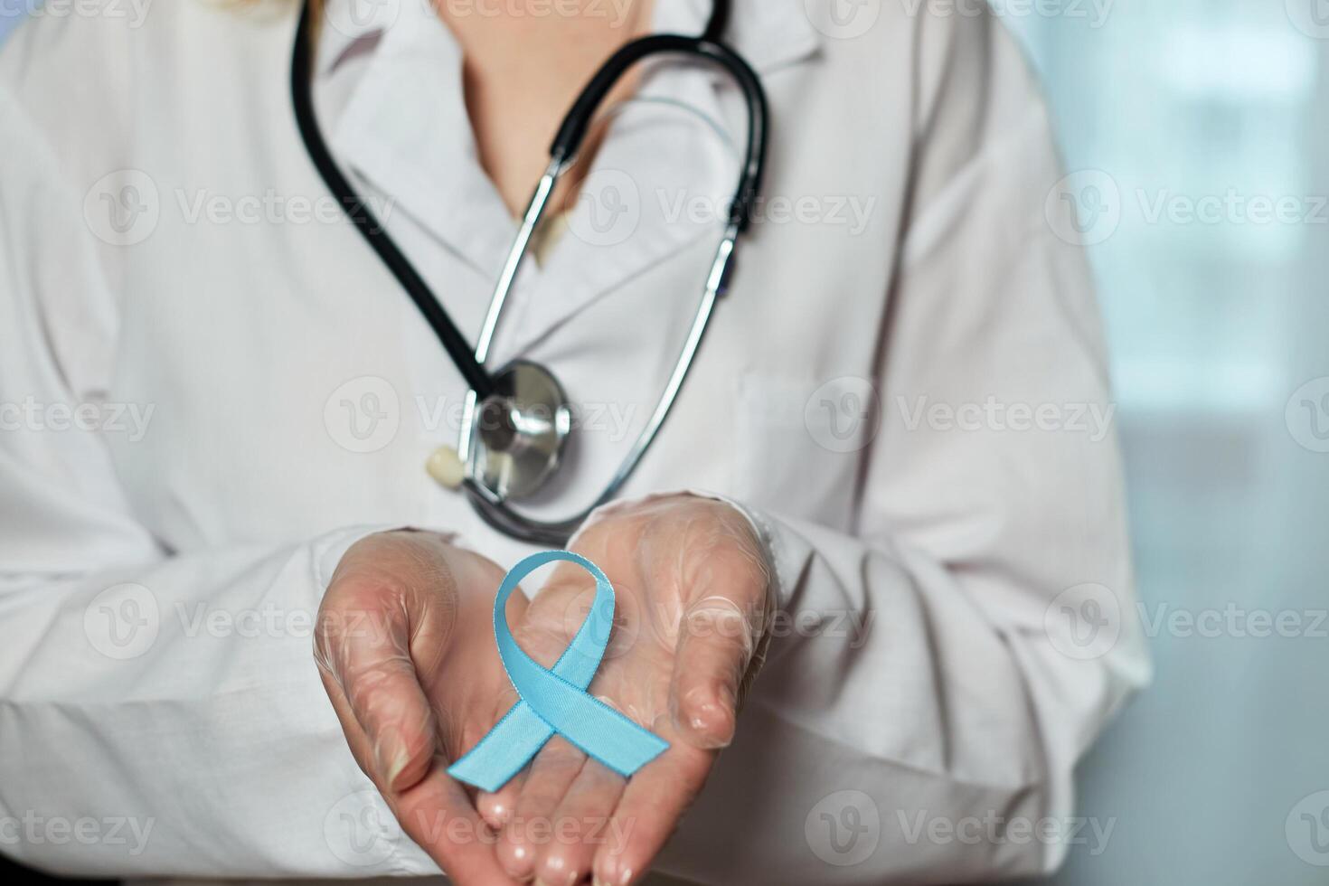 blå cancer medvetenhet band i de händer av en läkare. värld cancer dag foto