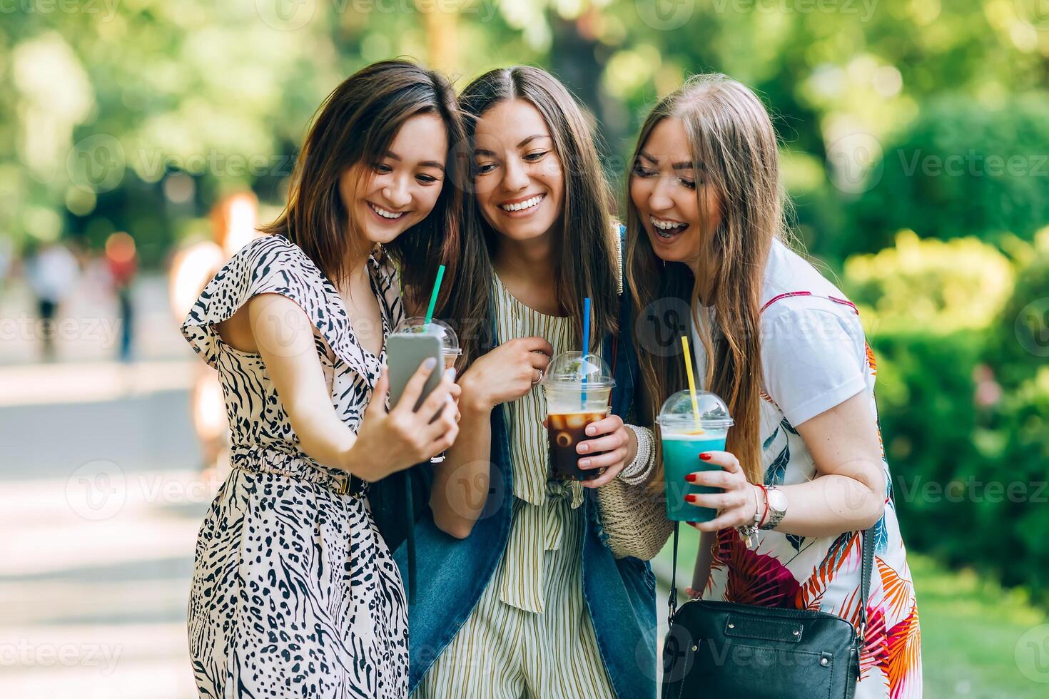 sommar livsstil porträtt raser kvinnor njut av trevlig dag, innehav glasögon av milkshakes. Lycklig vänner i de parkera på en solig dag. bäst vänner flickor har roligt, glädje. livsstil. asiatisk, judinna och foto