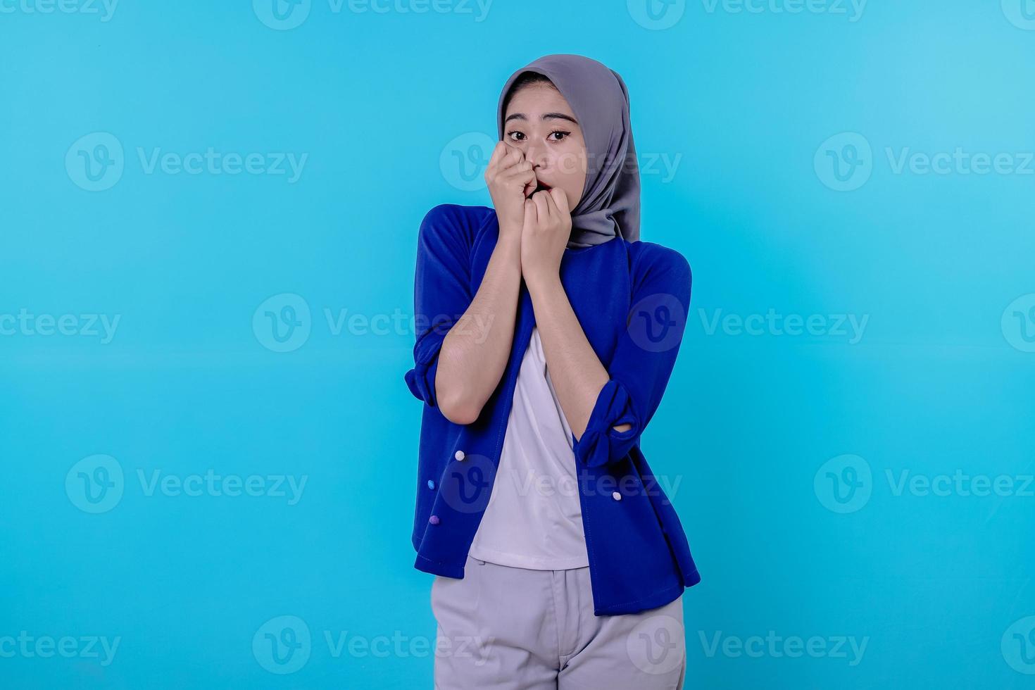 skrämde och förvånad ung kvinna iklädd hijab i skrik från skakade täckning med händer foto