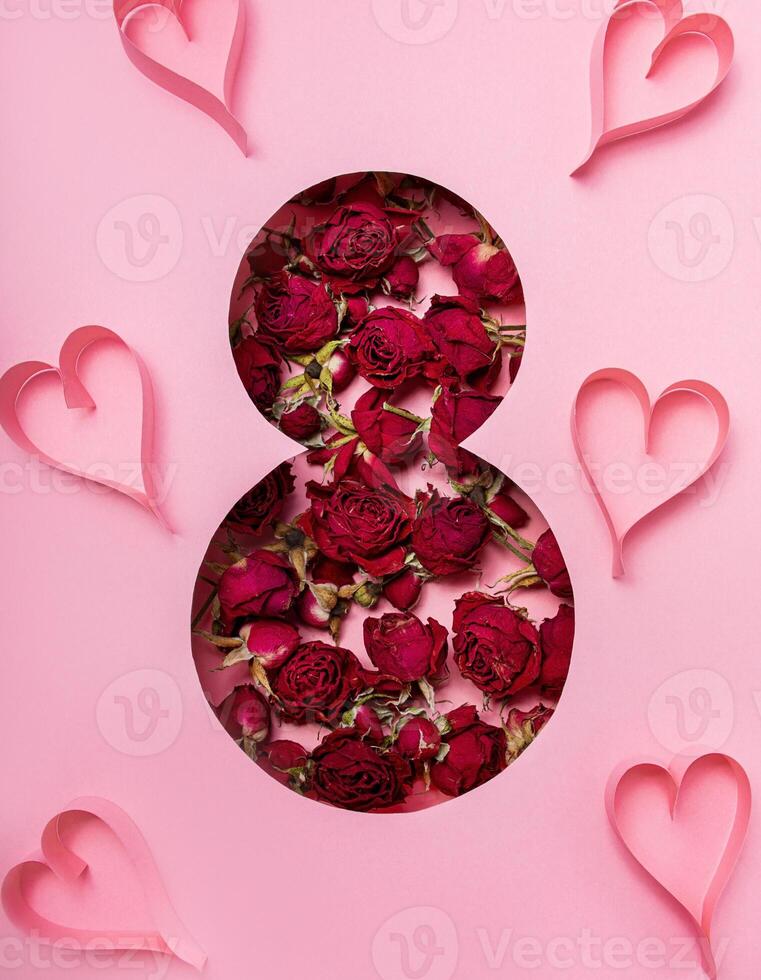 internationell kvinnors dag. vykort för Mars 8. torr blommor av ro och hjärtan i de form av de siffra åtta på en rosa bakgrund. baner kopia Plats. foto