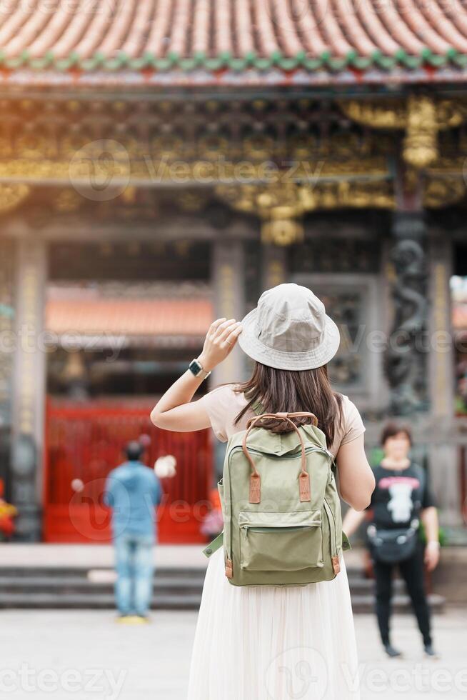 kvinna resande besöker i taiwan, turist med hatt sightseeing i longshan tempel, kinesisk folk religiös tempel i wanhua distrikt, taipei stad. landmärke och populär. resa och semester begrepp foto
