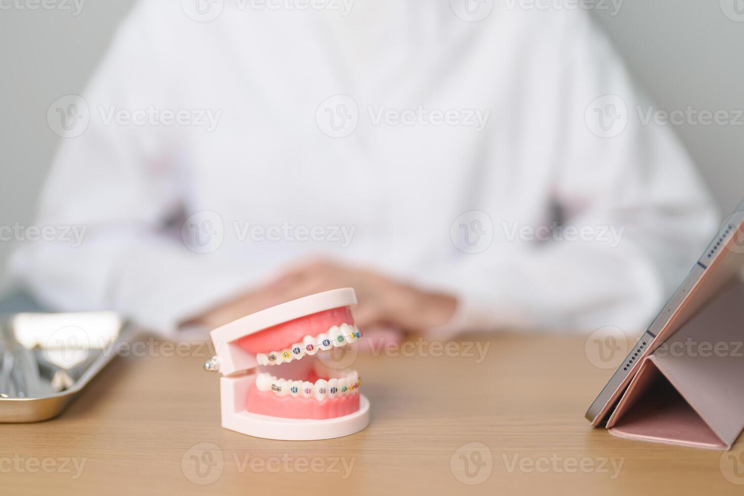 tandläkare med ortodontisk tand modell och konsol eller spänna. rena och skrapa av tandsten. Maj ortodontisk hälsa dag, Mars oral hälsa, tandläkare dag, falsk tänder. tandvärk och barn dental hälsa foto