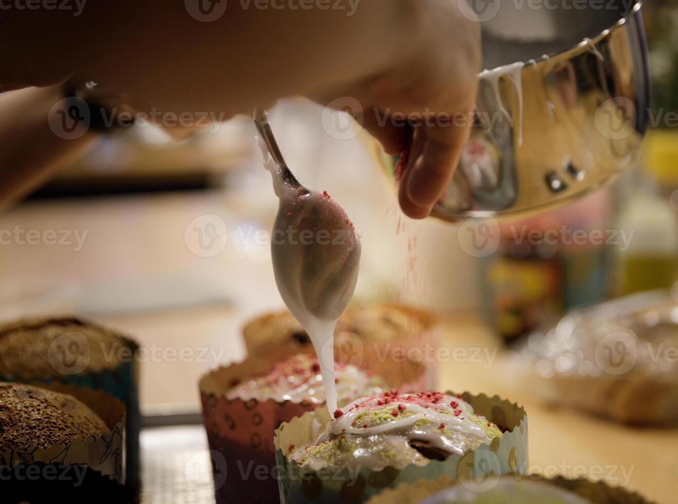 de kock händer smycka de muffins med glasyr socker och skivor av socker. bakgrund suddig, selektiv fokus.hög kvalitet Foto