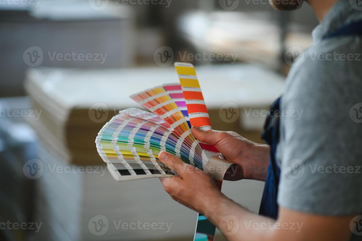 rolig porträtt av typograf stående med Färg färgrutor på de utskrift tillverkning foto