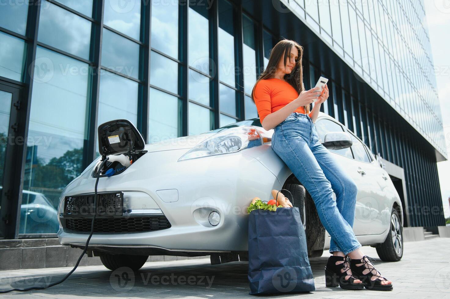 kvinna är laddning uthyrning elektrisk bil foto