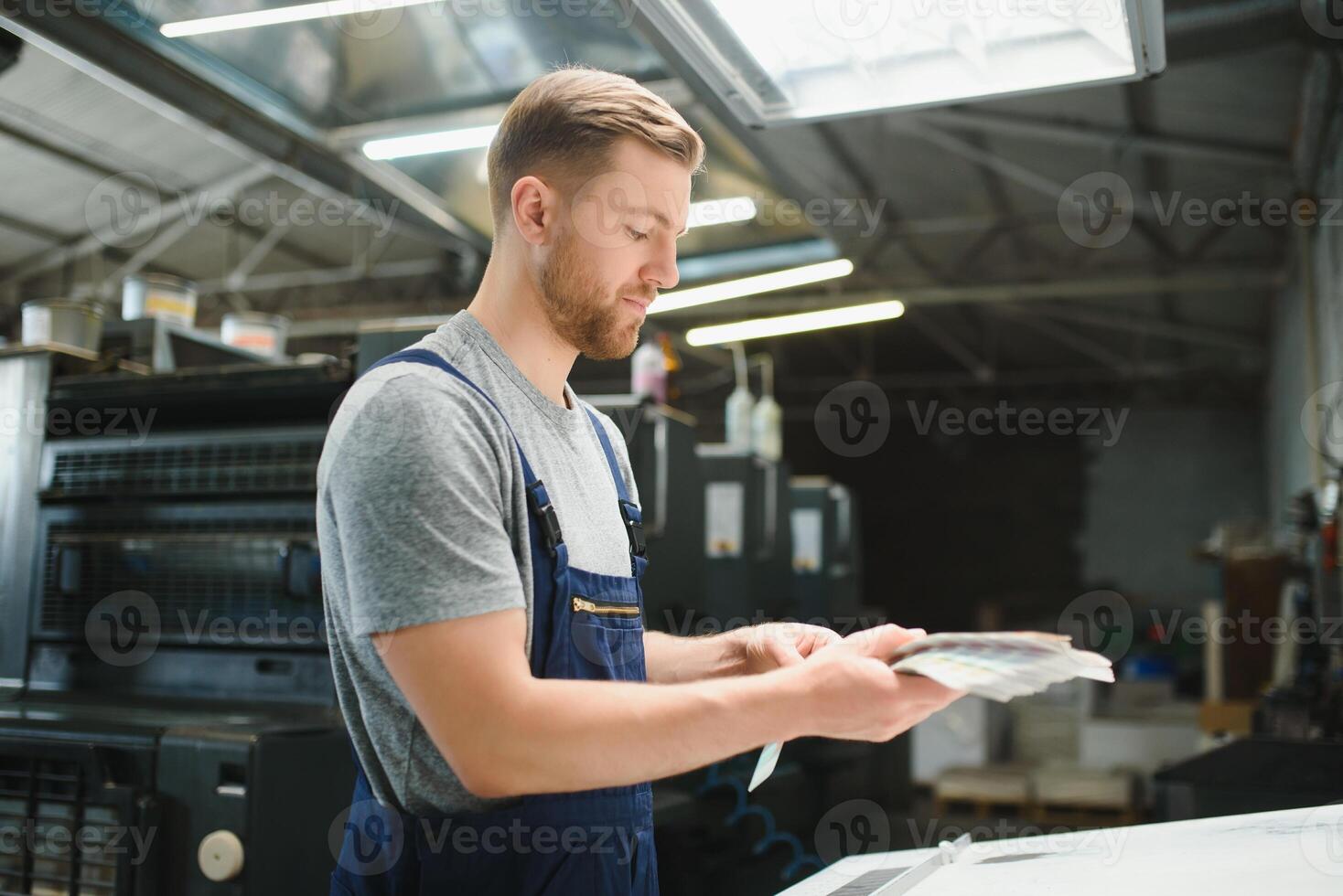 porträtt av produktion linje arbetstagare kontrollerande tillverkning bearbeta av modern förpackning industriell maskin i utskrift fabrik foto