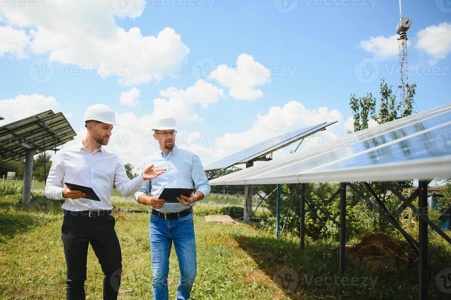 de sol- bruka sol- panel med två ingenjörer promenad till kolla upp de drift av de systemet, alternativ energi till bevara de världens energi, solceller modul aning för rena energi produktion foto