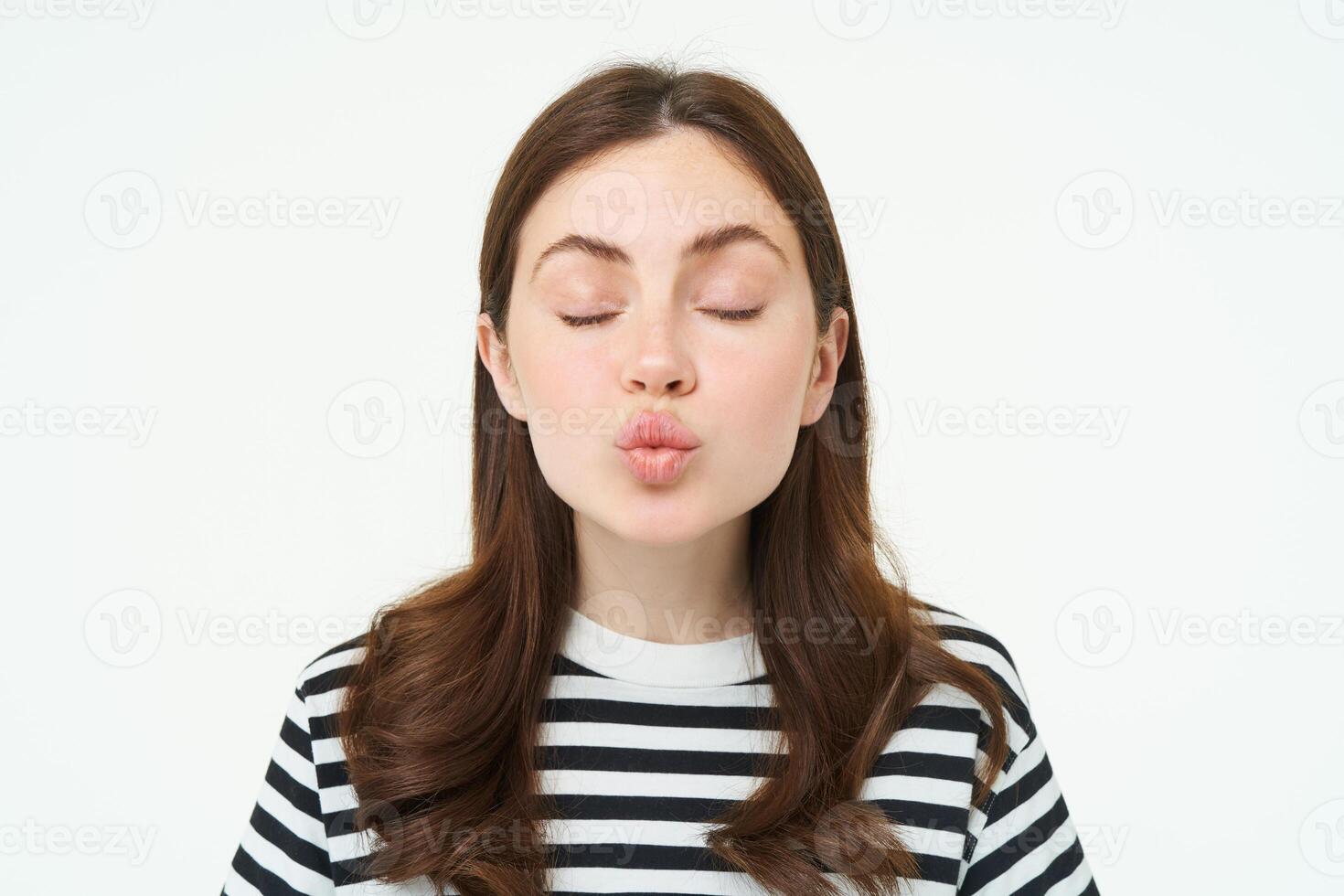 porträtt av kvinna står med stängd ögon och väntar för kyss, rynka mun, kyssar, isolerat över vit bakgrund foto