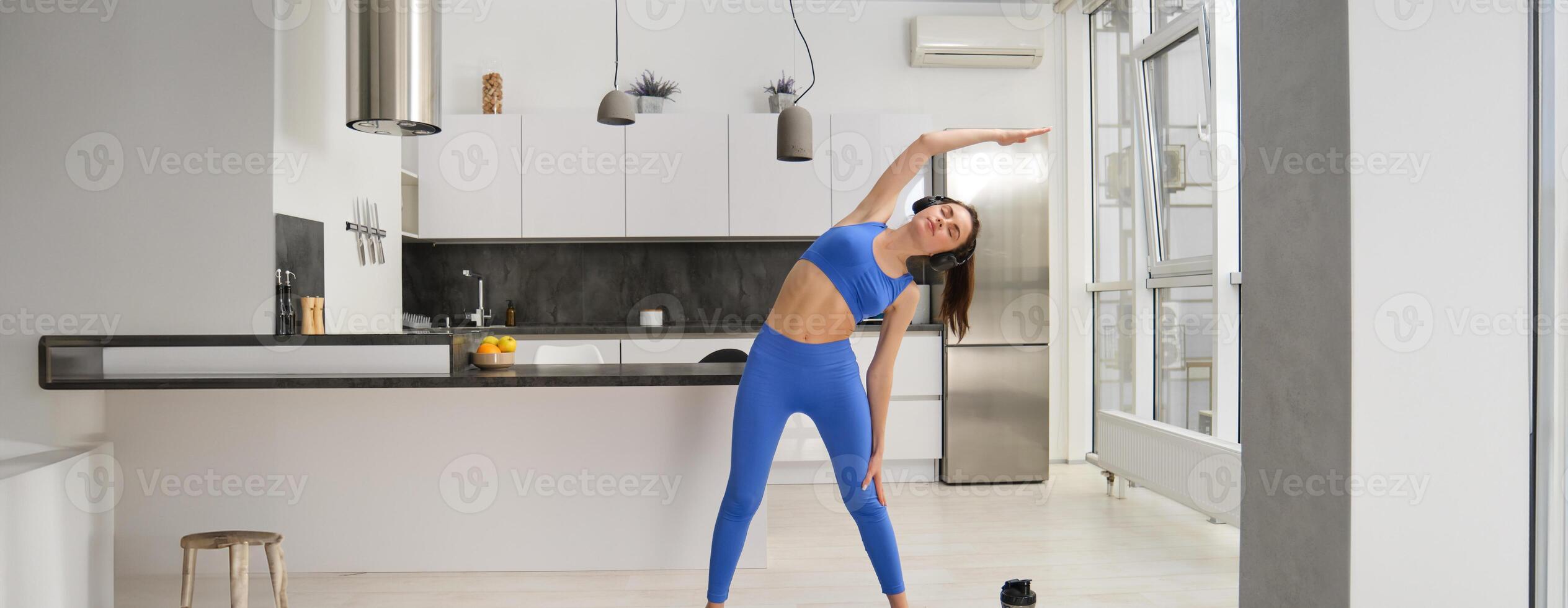 porträtt av ung kvinna håller på med aerobics övningar i levande rum, sport Träning på Hem, stående på sudd kondition matta och håller på med träna foto