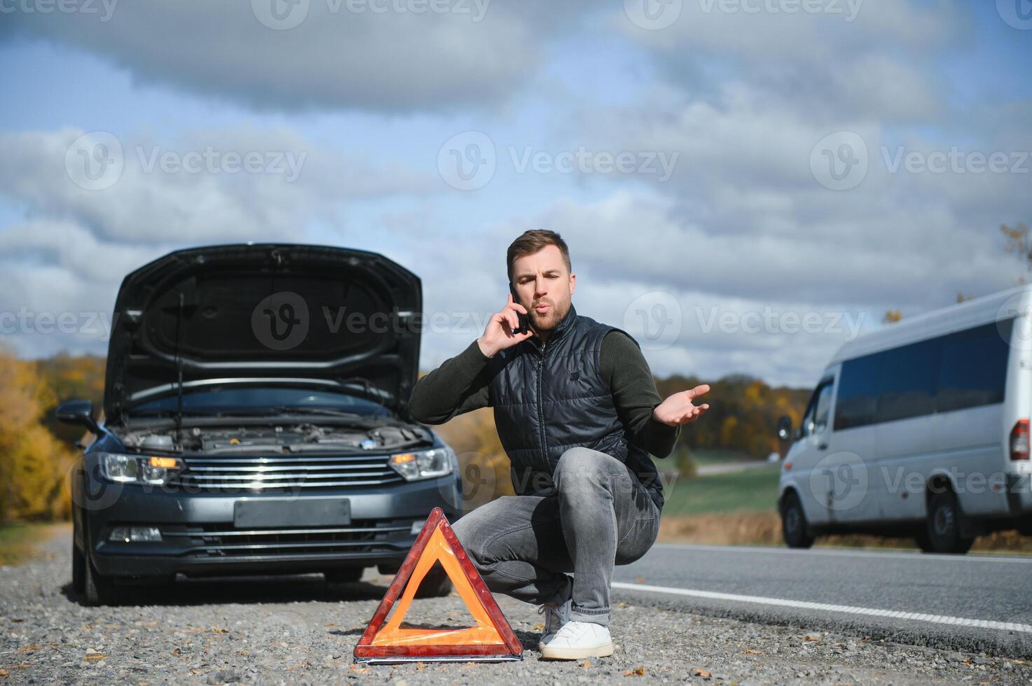 man med bruten bil i de mitten av de väg. foto