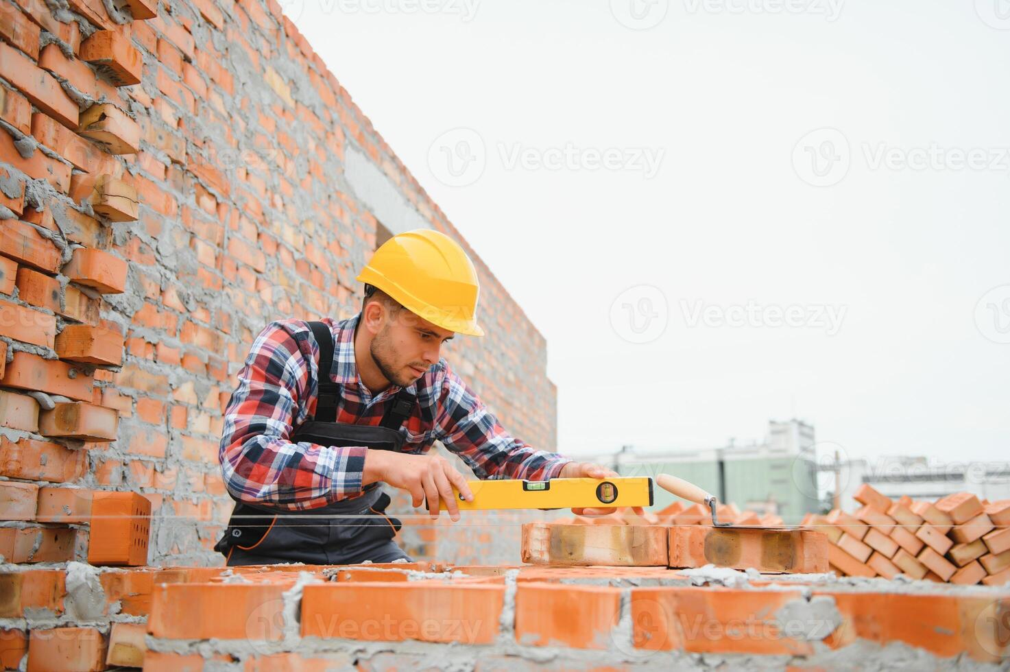 konstruktion murare arbetstagare murare montera röd tegel med murslev Spackel kniv utomhus. foto