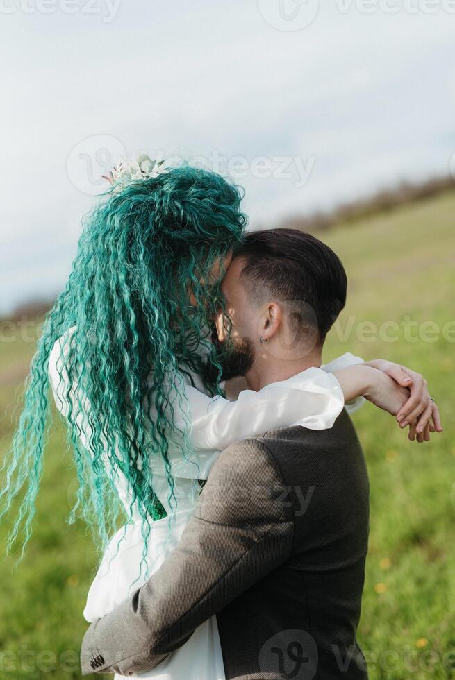 en skäggig brudgum och en flicka med grön hår dansa och snurra foto