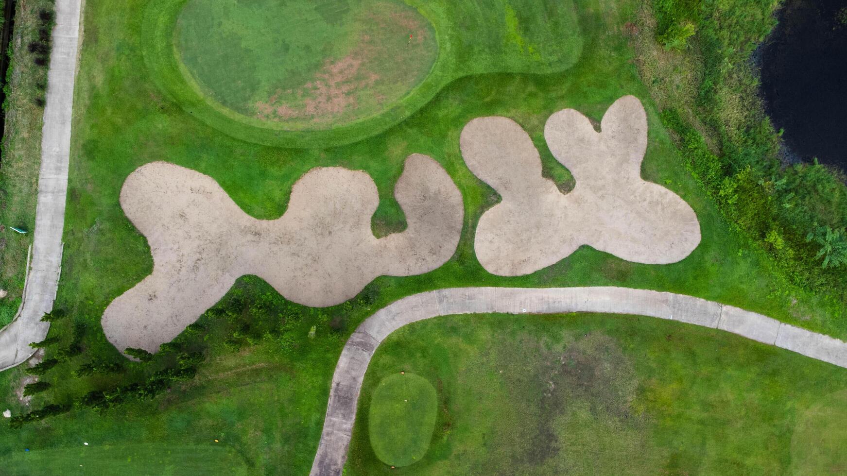 antenn se av golf kurs med en rik grön torva skön landskap. sand bunkrar på en skön golf kurs förbi de damm. foto