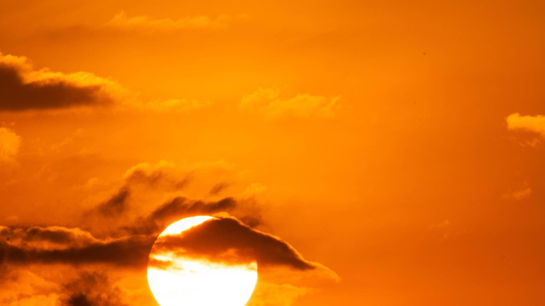 skön natur morgon- med orange, gul solsken och fluffig moln. tid upphöra av en skön dramatisk himmel med en stor Sol på soluppgång. foto