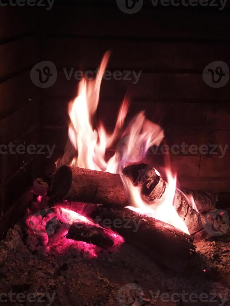 ljus lågor belysa en brinnande brand i en öppen spis foto