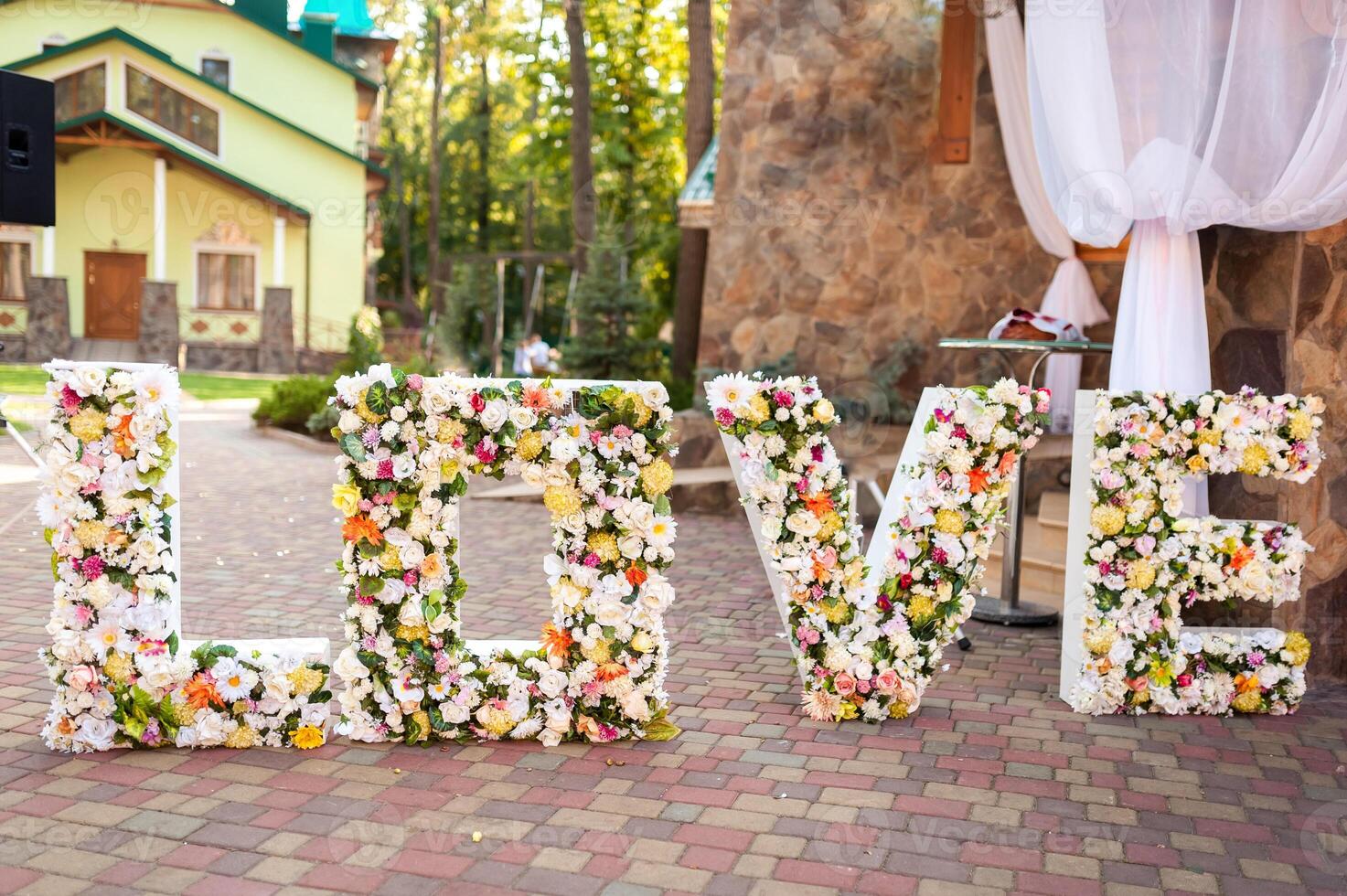 dekorerad för bröllop ceremoni. ord kärlek dekorerad av blommor på bröllop ceremoni foto