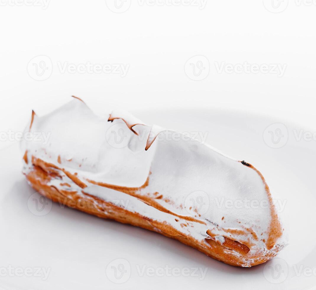 eclair med maräng på vit tallrik foto