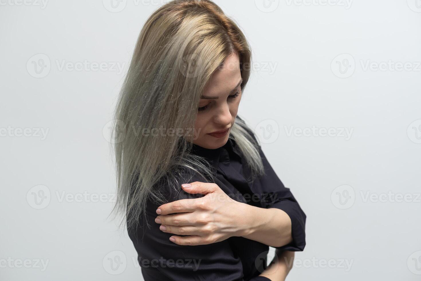 kvinnas hand i vit t-shirt Rör henne övre ärm , ärm smärta och muskel skada begrepp. foto