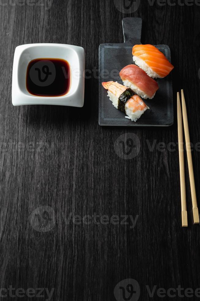 nigiri sushi på träbord i en japansk restaurang. kopieringsutrymme och ovanifrån foto