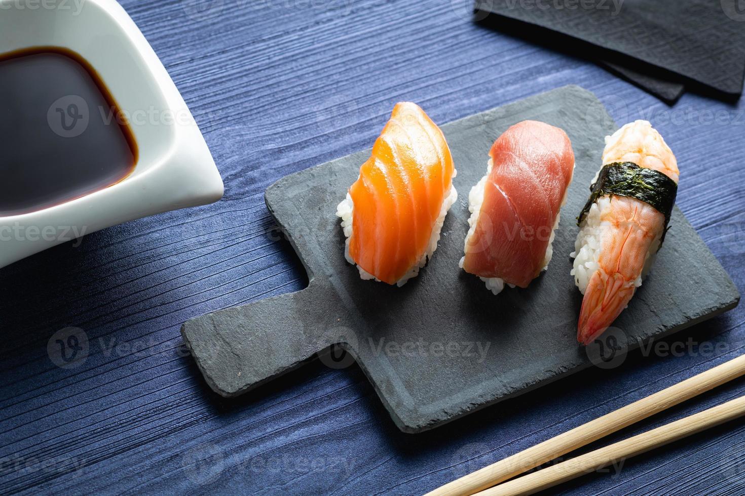elegant sushi på träbord. lite nigiri, med sojasås och ätpinne foto