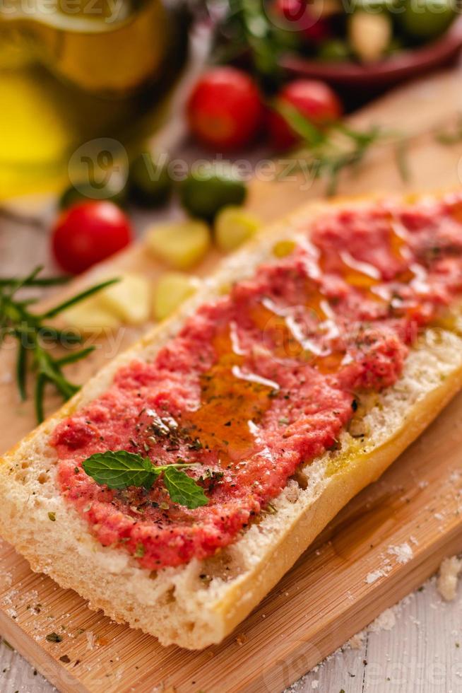 rustikt bröd, tomat och olivolja redo att göra rostat bröd foto