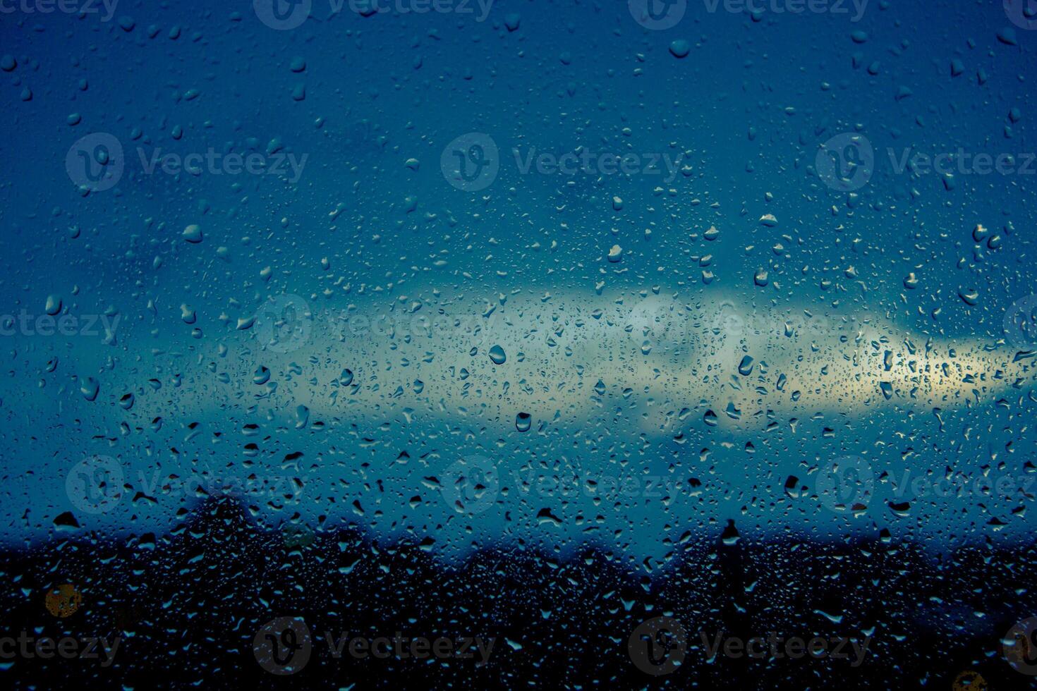 närbild av droppar på fönster. bakgrund av rör på sig regn droppar på en fönster glas i en regnig dag. foto