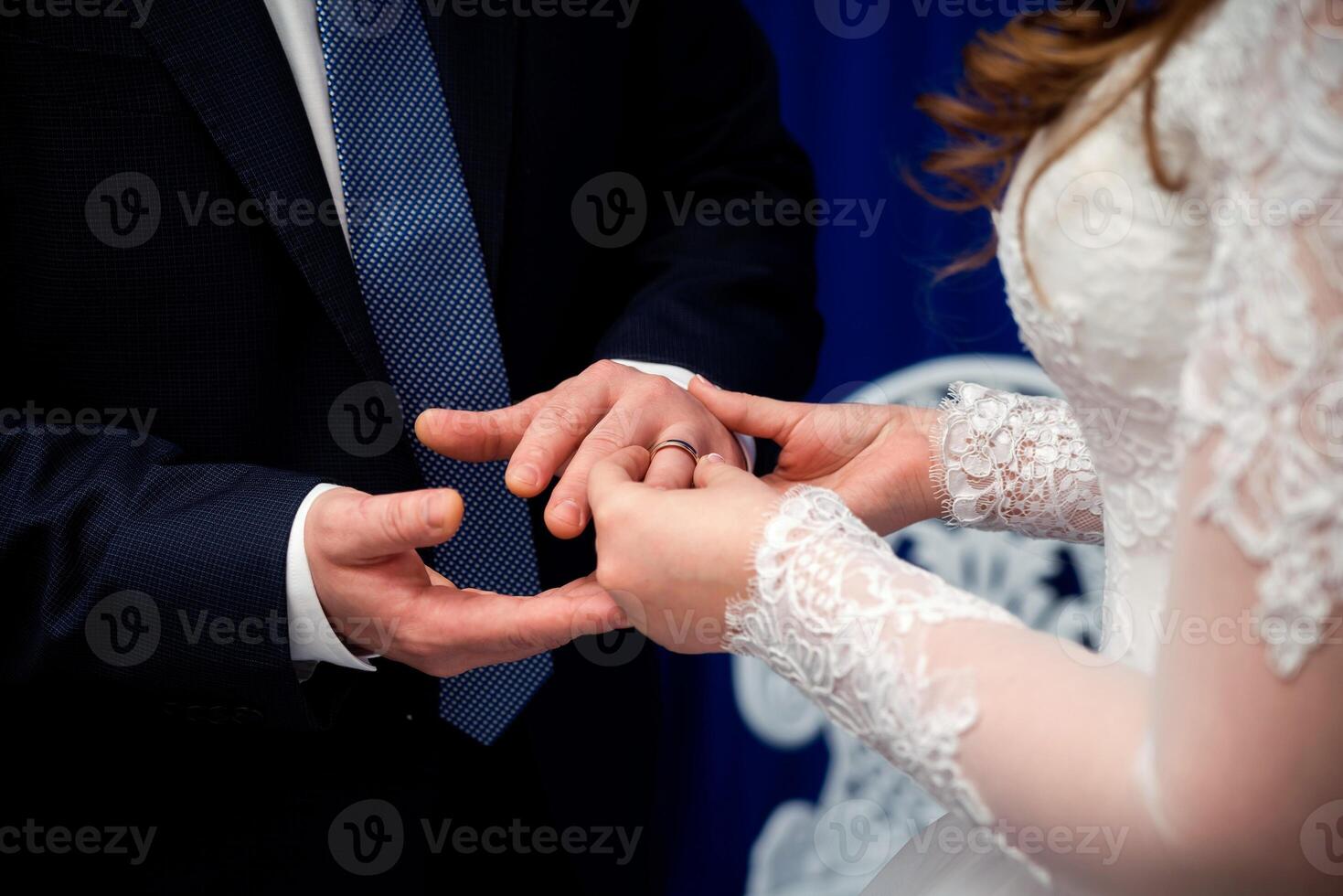 brud är sätta gyllene ringa på brudgummens finger under bröllop ceremoni. händer av en kärleksfull par med bröllop ringar foto