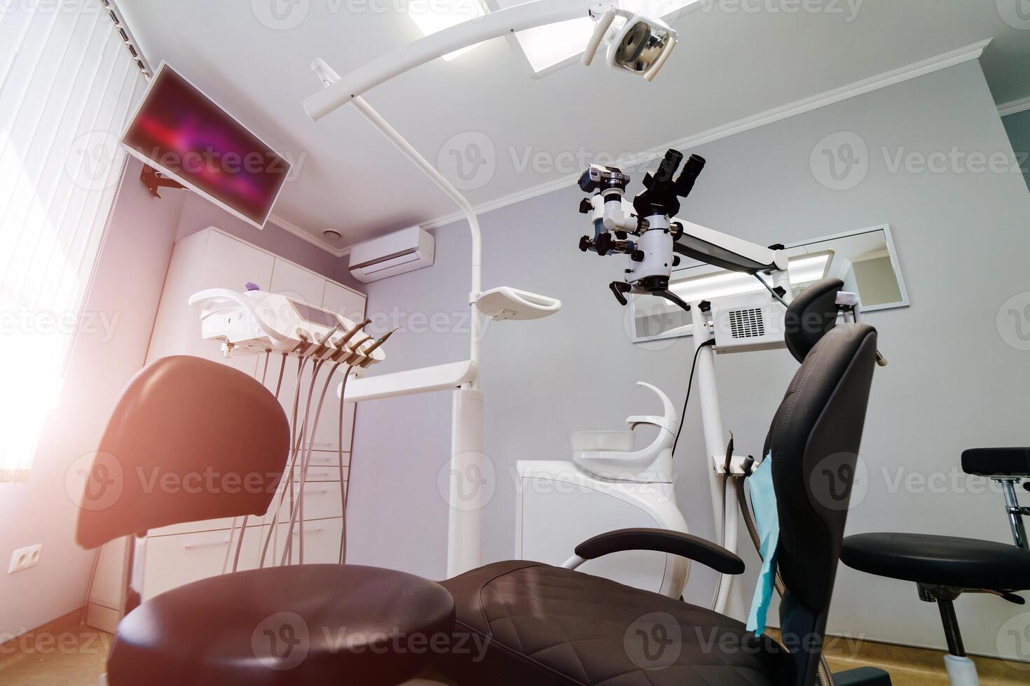 modern tandvård kontor interiör med stol och verktyg. mikroskop i stomatologi. foto