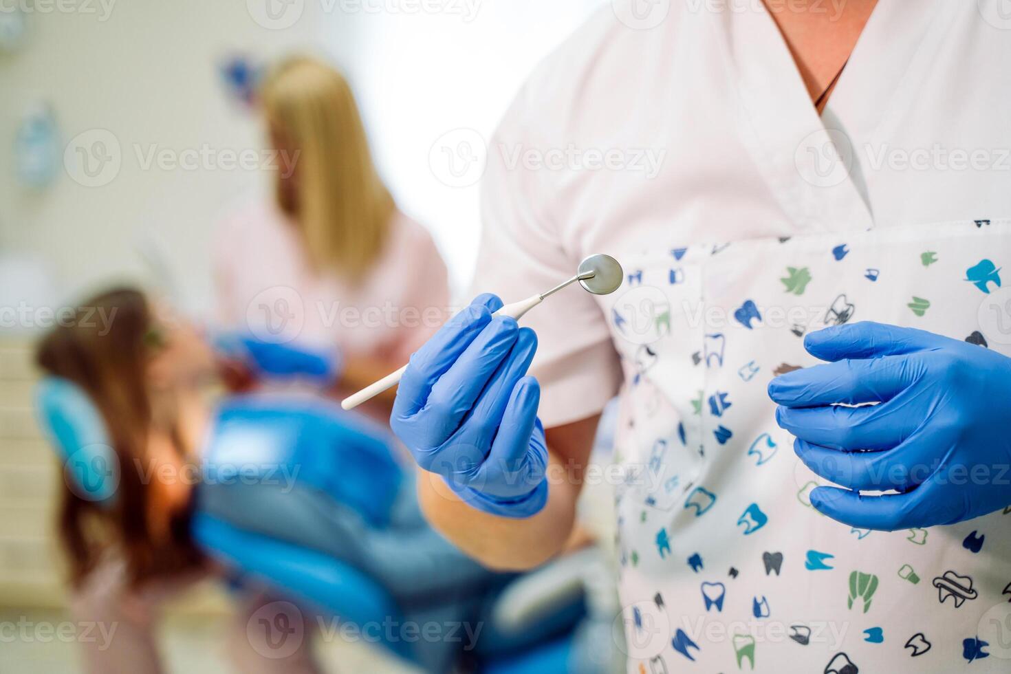 tandläkare i de handskar innehar verktyg spegel. stomatologisk instrument i de tandläkarens klinik. team arbetssätt på de bakgrund. selektiv fokus. närbild foto