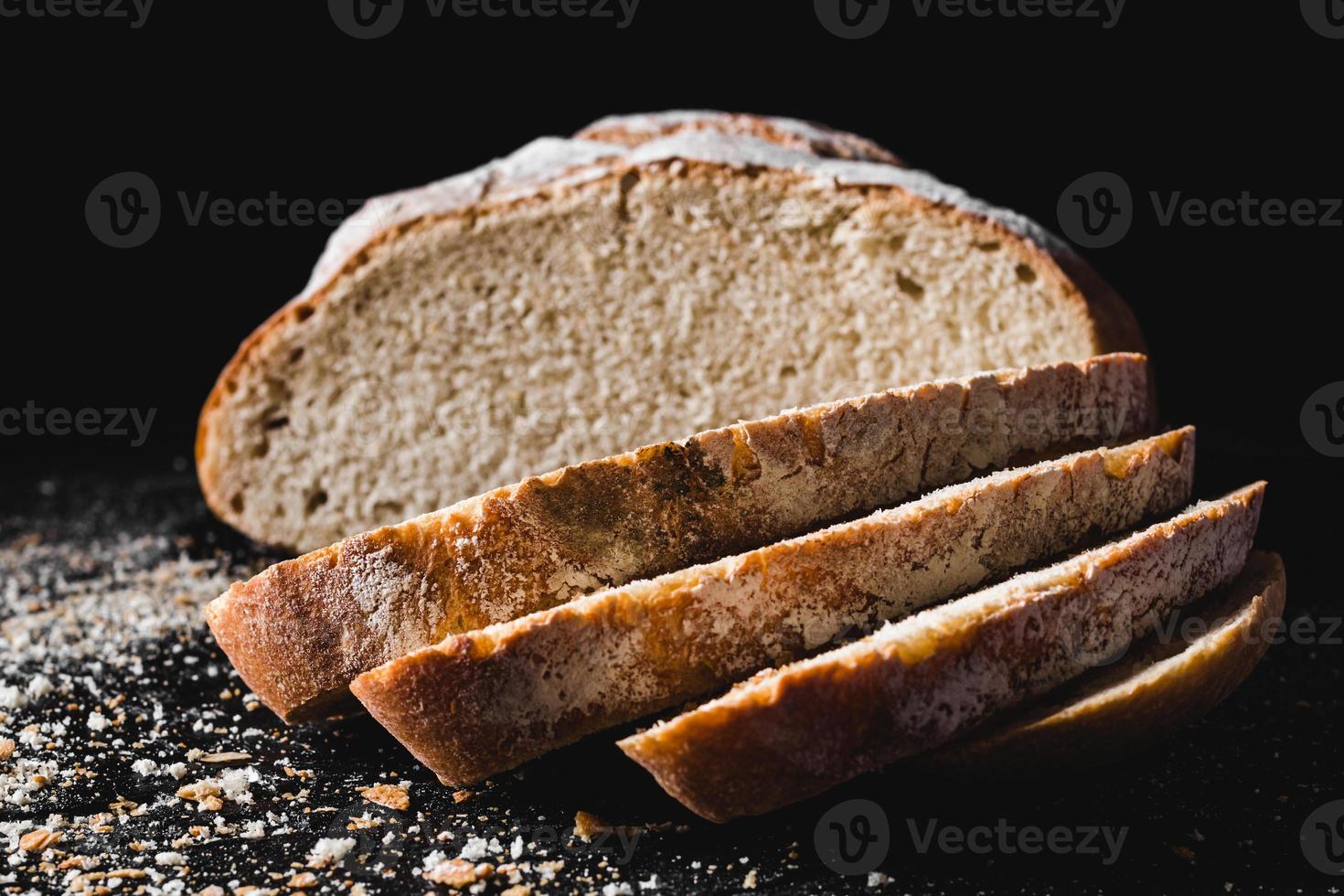 skivad limpa mörkt hembakat bröd pudrat med mjöl foto