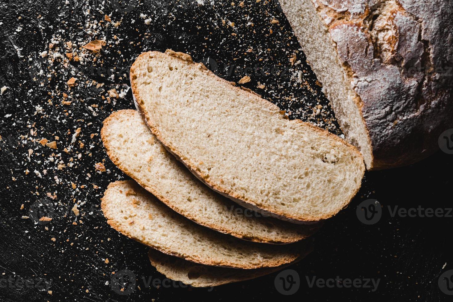 skivad limpa mörkt hembakat bröd pudrat med mjöl foto