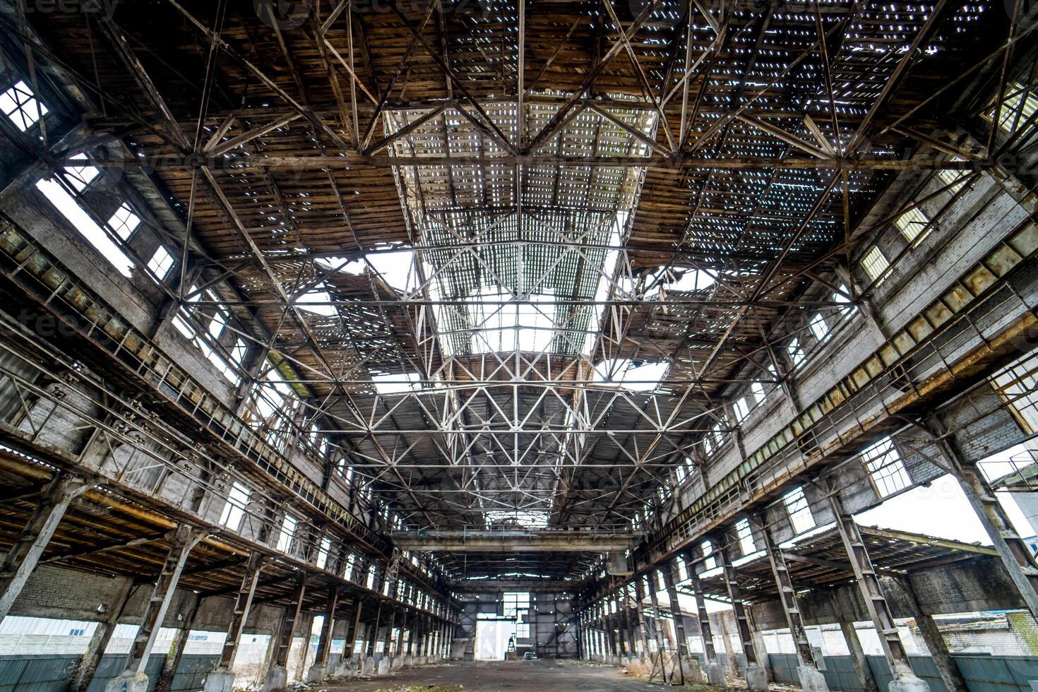 ljus industriell interiör av ett gammal byggnad med skadad tak och väggar. övergiven arkitektur av stor bruten lager inuti, ruiner och rivning begrepp. foto