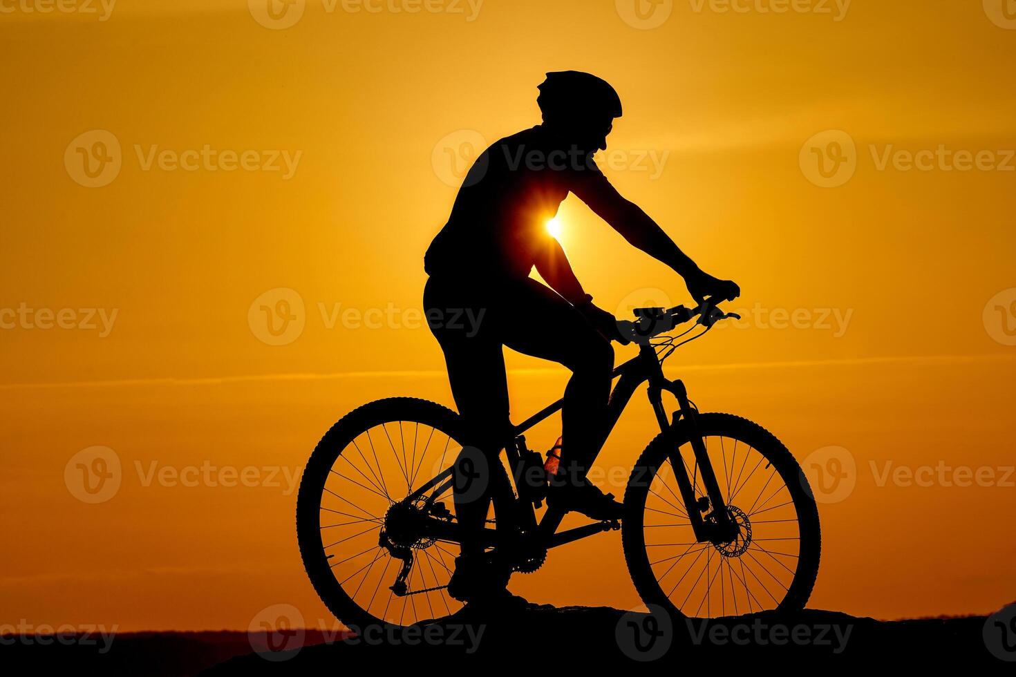 silhuett av en sportig cyklist i hjälm på en cykel. aktiva livsstil begrepp foto