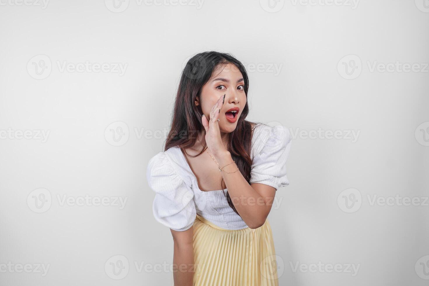 en ung skön asiatisk kvinna är skrikande och skrikande högt med en hand på henne mun, isolerat förbi vit bakgrund. foto