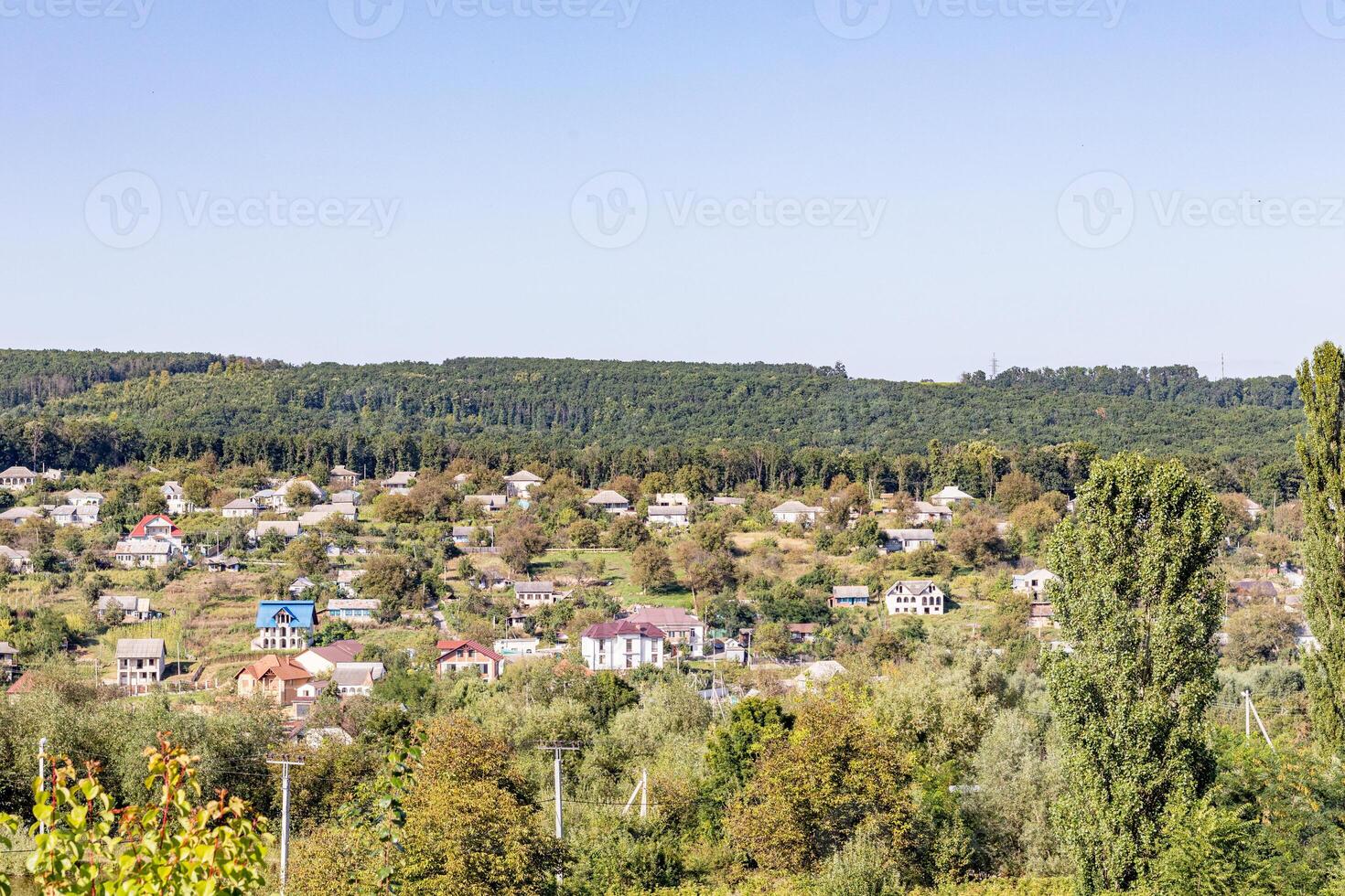 naturskön se av en lantlig landskap med frodig grönska och spridd hus under en klar blå himmel i moldavien foto