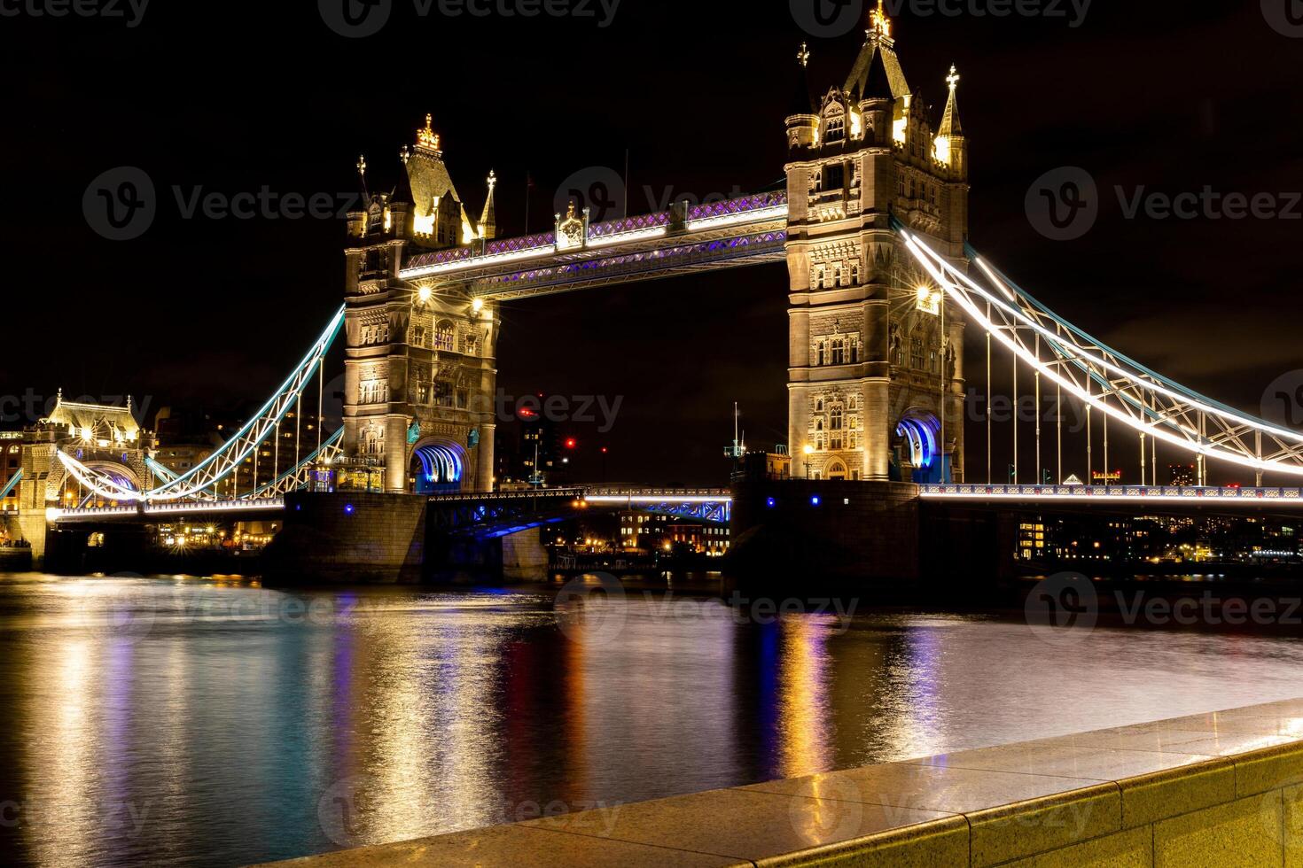 upplyst torn bro i London på natt med reflektioner på de thames flod. foto