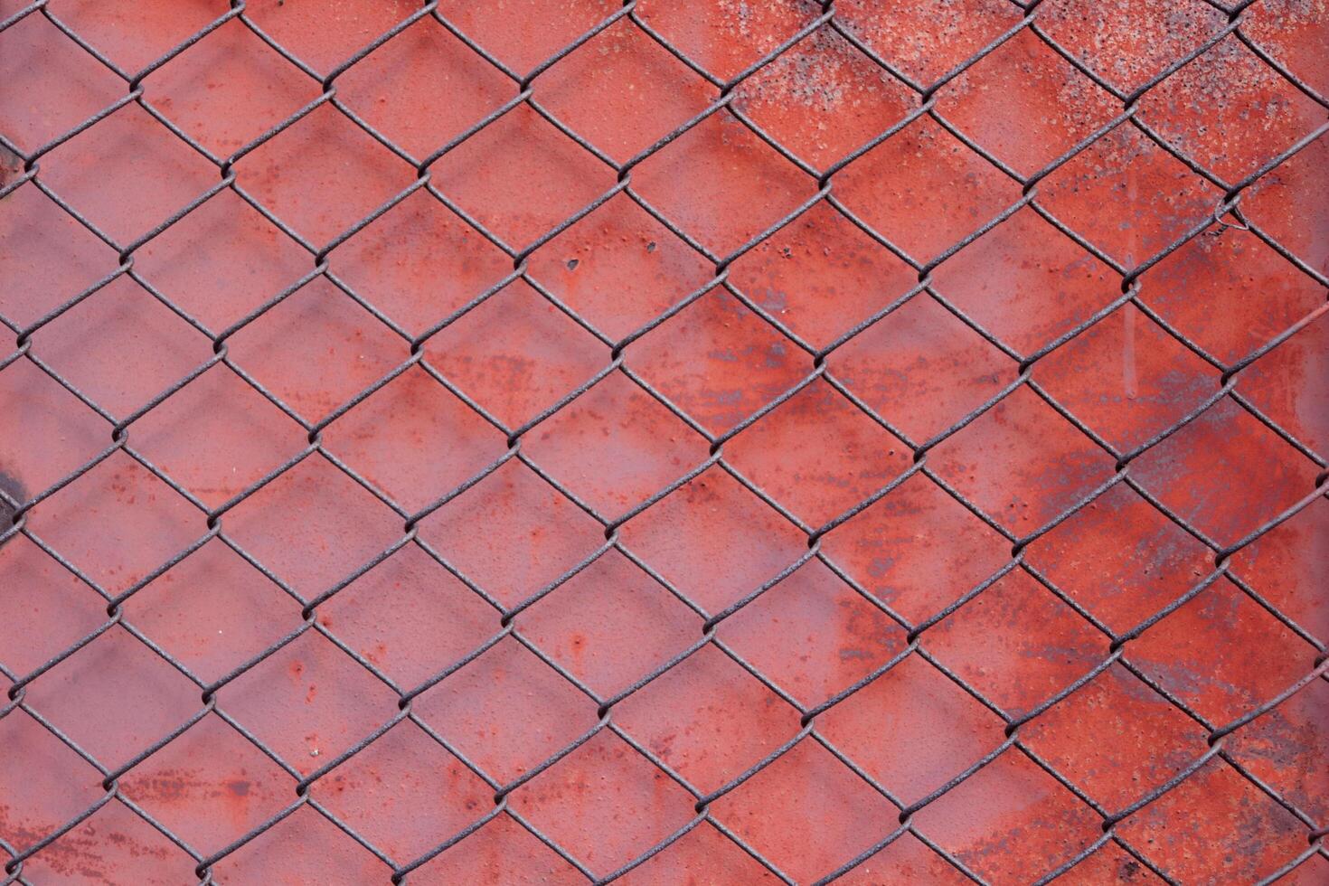 kedja länk fäktning maska eller tråd flor främre röd målad och förfall med rostig yta metall bakgrund. foto