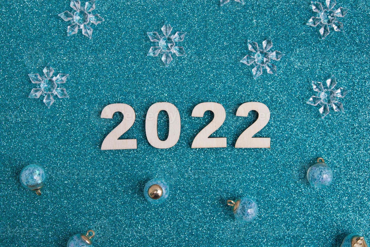 tränummer nyår 2022 med juldekor på glitterblå bakgrund foto