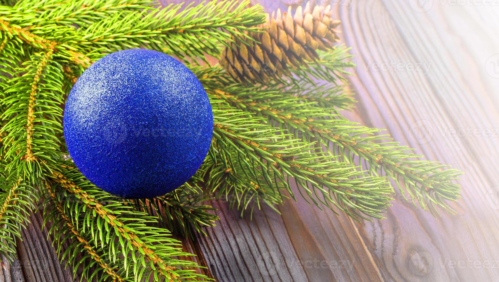 de grenar av en jul träd dekorerad med blå boll med silke på en trä- tabell foto