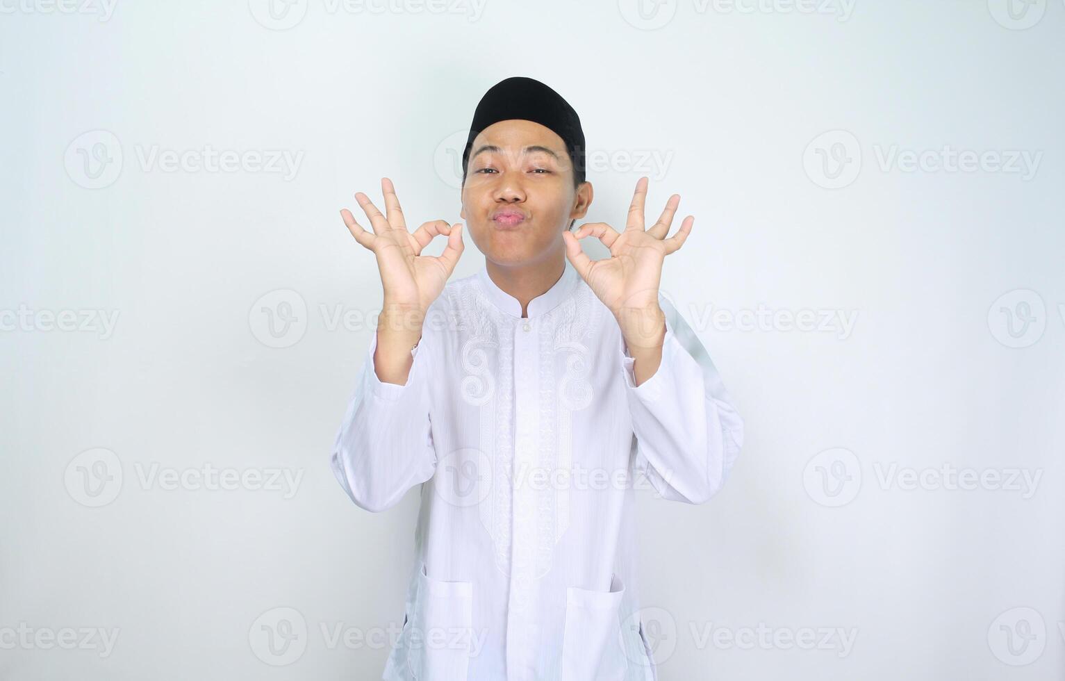Lycklig muslim asiatisk man visa ok tecken för gott mat isolerat på vit bakgrund foto