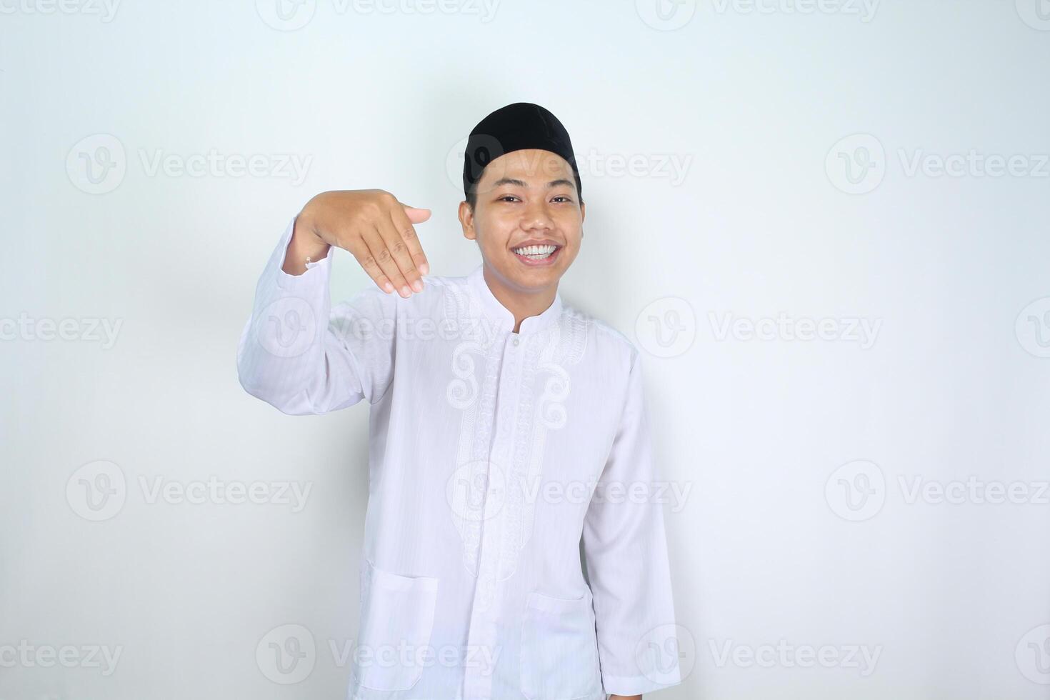 leende muslim asiatisk man visa inbjudande gest med ser på kamera isolerat på vit bakgrund foto
