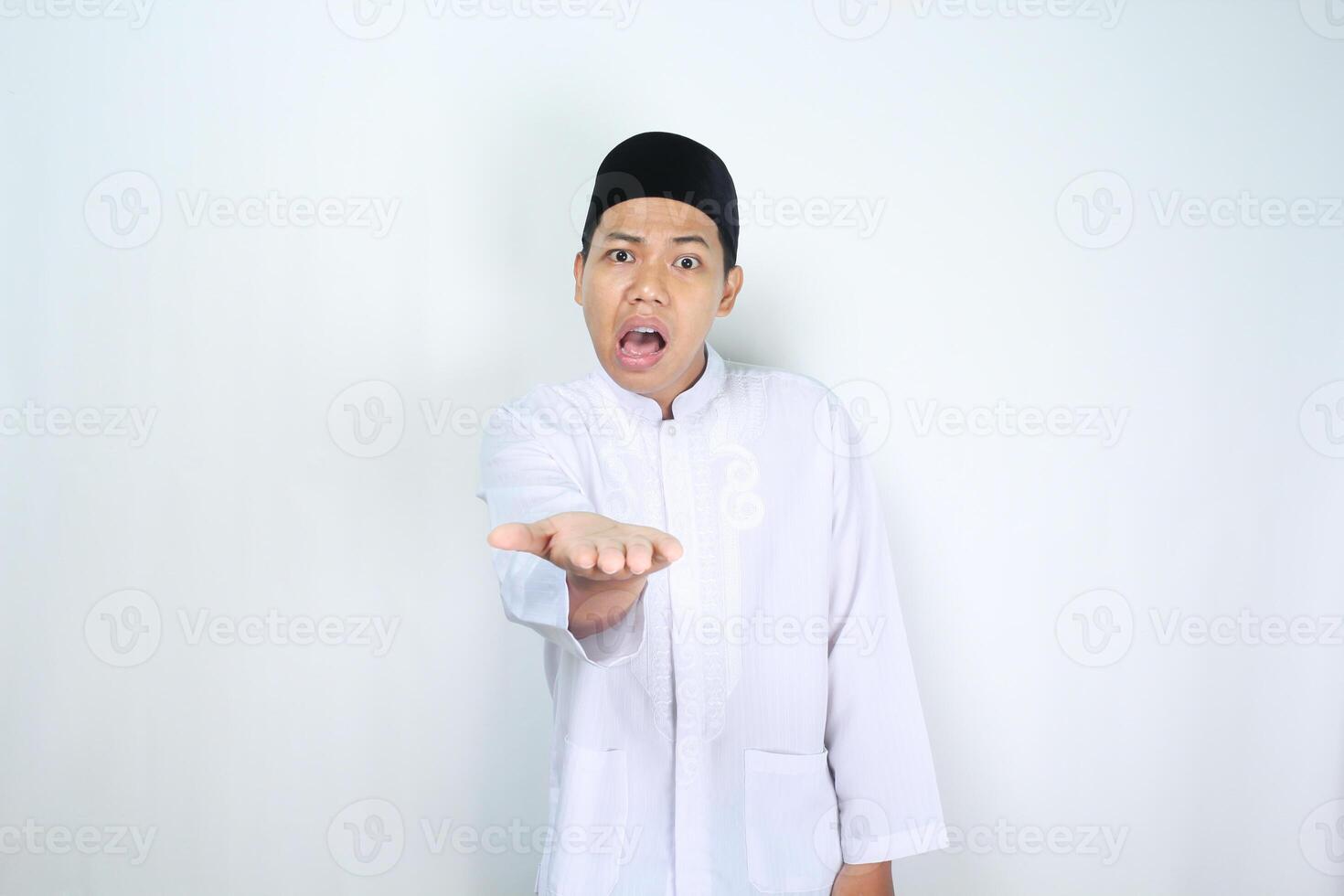 asiatisk man muslim höjning hand framåt- till presenter med chock ansikte uttryck isolerat på vit bakgrund foto