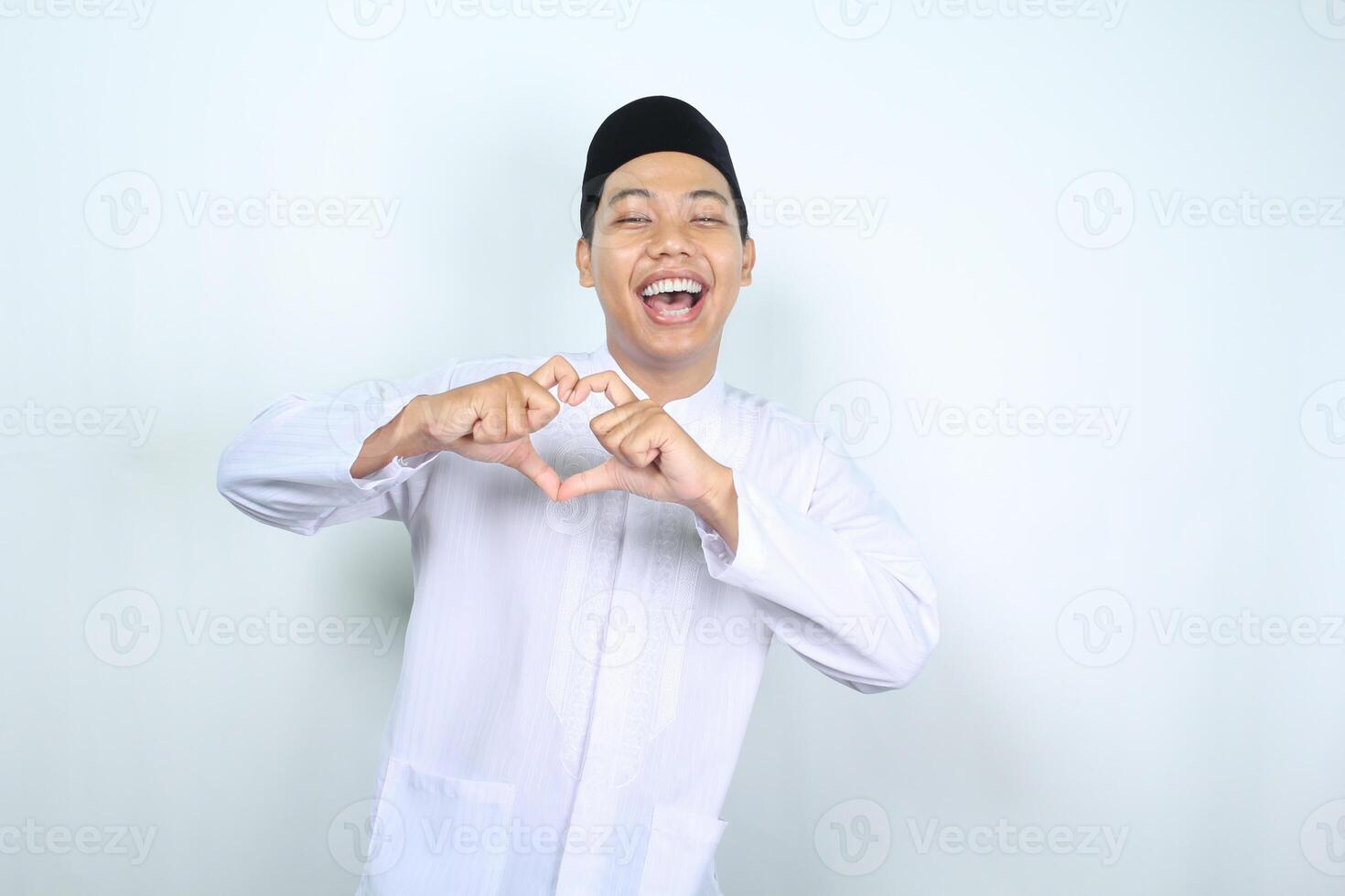 upphetsad asiatisk muslim man som visar hjärta form isolerat på vit bakgrund foto