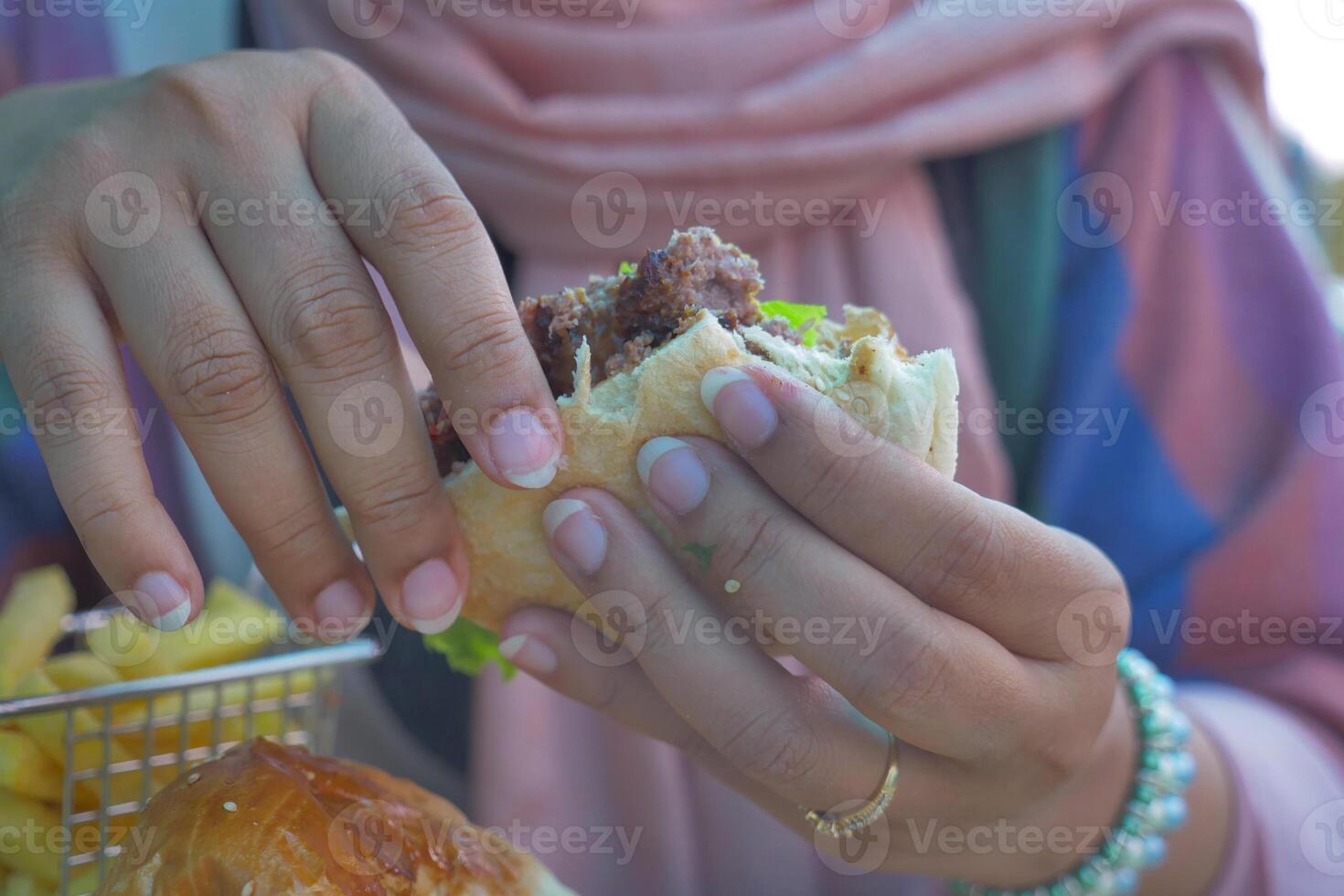 halv uppäten nötkött burger på hand foto