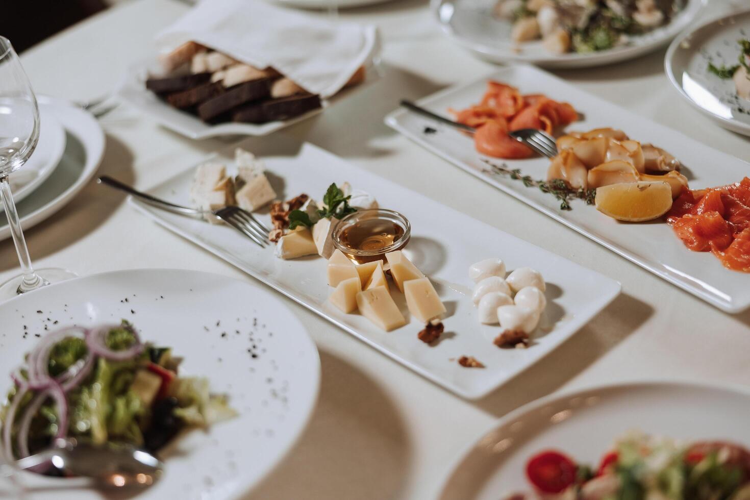 en se av bröllop bord, uppmärksamhet till servering, med blomma arrangemang, dyr bestick, plattor med vit servetter. foto