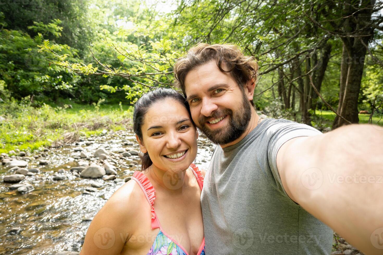 latinamerikan par tar en selfie i en flod i Cordoba, argentina, de är på semester njuter de ström. foto