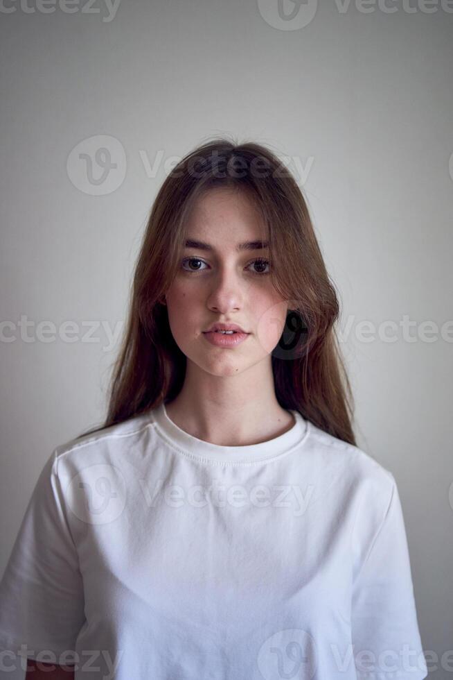 porträtt av en skön Tonårs flicka på en stol i en ljus rum i en minimalistisk stil foto
